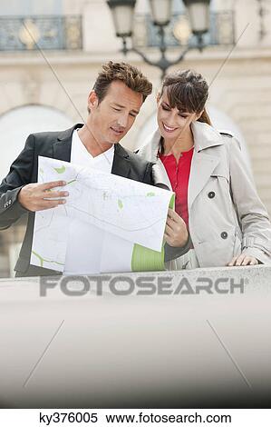 Stock Photography - Couple reading a map, Paris, Ile-de-France, France. Fotosearch