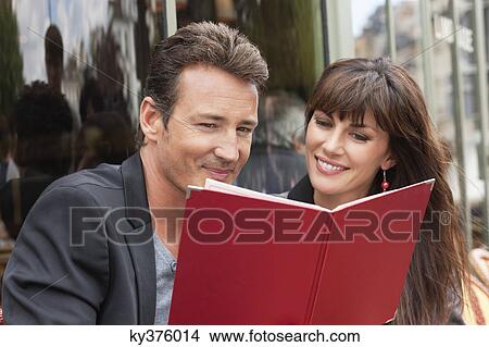 Picture - Couple reading menu at a restaurant, Paris, Ile-de-France, France. Fotosearch
