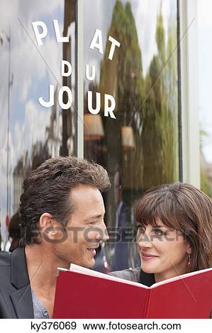 Stock Photo - Couple reading menu at a restaurant, Paris, Ile-de-France, France. Fotosearch