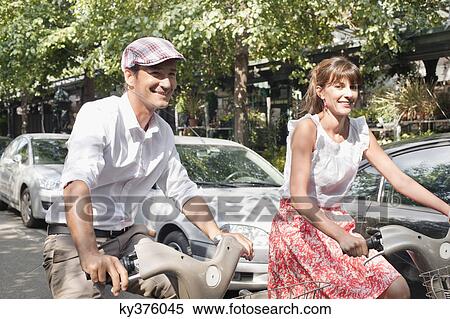 Stock Photography - Couple riding bicycles, Paris, Ile-de-France, France. Fotosearch
