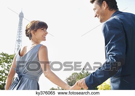 Couple smiling at each other with the Eiffel Tower in the background, Paris, Ile-de-France, France View Large Photo Image Stock Photography - Couple smiling at each other with the Eiffel Tower in the background, Paris, Ile-de-France, France. Fotosearch