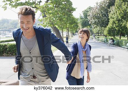 Stock Image - Couple walking with the Eiffel Tower in the background, Paris, Ile-de-France, France. Fotosearch