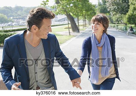 Couple walking with the Eiffel Tower in the background, Paris, Ile-de-France, France View Large Photo Image Stock Photograph - Couple walking with the Eiffel Tower in the background, Paris, Ile-de-France, France. Fotosearch