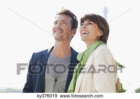 Stock Photo - Happy couple with the Eiffel Tower in the background, Paris, Ile-de-France, France. Fotosearch