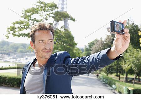 Man taking a picture of himself with a digital camera with the Eiffel Tower in the background, Paris, Ile-de-France, France View Large Photo Image Stock Image - Man taking a picture of himself with a digital camera with the Eiffel Tower in the background, Paris, Ile-de-France, France. Fotosearch