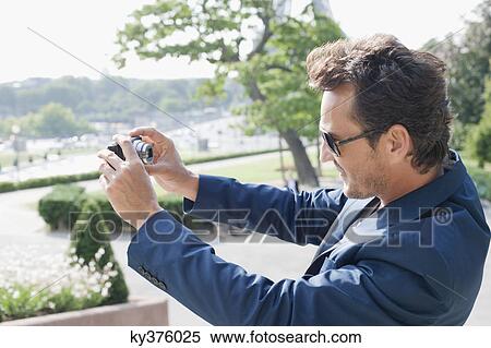 Man taking a picture of himself with a digital camera, Eiffel Tower, Paris, Ile-de-France, France View Large Photo Image Stock Photography - Man taking a picture of himself with a digital camera, Eiffel Tower, Paris, Ile-de-France, France. Fotosearch