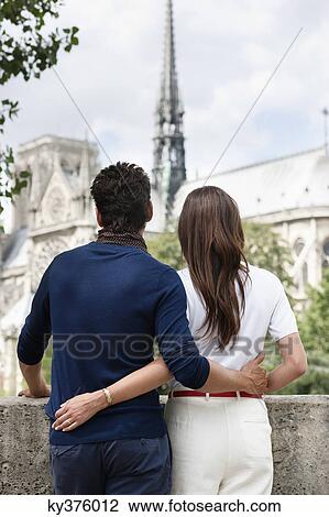 Stock Image - Romantic couple with Notre Dame de Paris in the background, Paris, Ile-de-France, France. Fotosearch