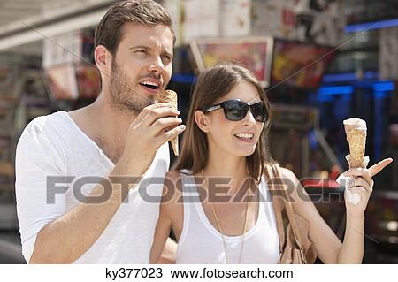 Stock Image - Couple eating ice creams, Paris, Ile-de-France, France. Fotosearch