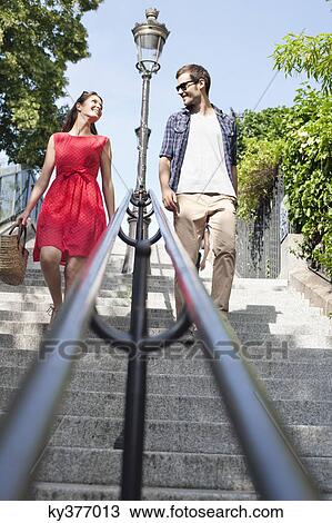 Stock Image - Couple moving down staircases, Montmartre, Paris, Ile-de-France, France. Fotosearch