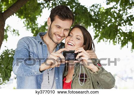 Couple taking a picture of themselves with a digital camera, Paris, Ile-de-France, France View Large Photo Image Stock Image - Couple taking a picture of themselves with a digital camera, Paris, Ile-de-France, France. Fotosearch