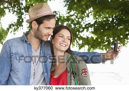 Couple taking a picture of themselves with a digital camera, Paris, Ile-de-France, France View Large Photo Image Stock Image - Couple taking a picture of themselves with a digital camera, Paris, Ile-de-France, France. Fotosearch