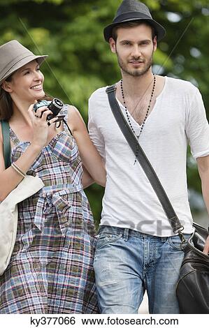 Stock Photograph - Couple walking on a road and smiling, Paris, Ile-de-France, France. Fotosearch