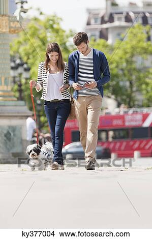 Couple walking with a puppy, Paris, Ile-de-France, France View Large Photo Image Picture - Couple walking with a puppy, Paris, Ile-de-France, France. Fotosearch