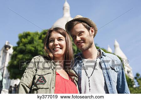 Stock Photo - Low angle view of a couple smiling, Montmartre, Paris, Ile-de-France, France. Fotosearch