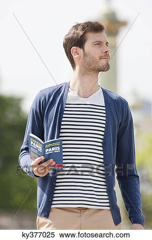 Man holding a travel guidebook, Paris, Ile-de-France, France View Large Photo Image Stock Photography - Man holding a travel guidebook, Paris, Ile-de-France, France. Fotosearch