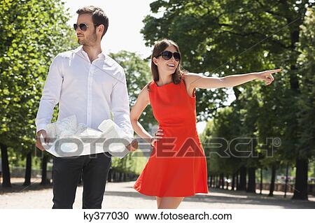 Man reading a map with a woman pointing, Terrasse De l'Orangerie, Jardin des Tuileries, Paris, Ile-de-France, France View Large Photo Image Stock Image - Man reading a map with a woman pointing, Terrasse De l'Orangerie, Jardin des Tuileries, Paris, Ile-de-France, France. Fotosearch