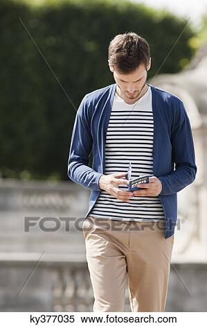 Man reading a travel guidebook, Paris, Ile-de-France, France View Large Photo Image Stock Photography - Man reading a travel guidebook, Paris, Ile-de-France, France. Fotosearch