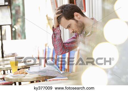 Man sitting at a sidewalk cafe and reading a map, Paris, Ile-de-France, France View Large Photo Image Stock Photo - Man sitting at a sidewalk cafe and reading a map, Paris, Ile-de-France, France. Fotosearch