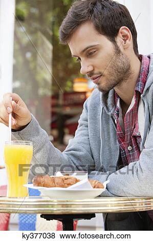 Stock Photo - Man sitting at a sidewalk cafe and thinking, Paris, Ile-de-France, France. Fotosearch