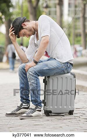 Man sitting on the suitcase at the roadside, Paris, Ile-de-France, France View Large Photo Image Stock Image - Man sitting on the suitcase at the roadside, Paris, Ile-de-France, France. Fotosearch