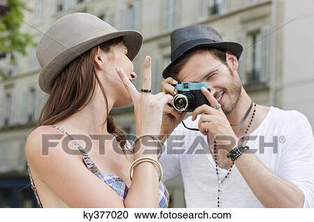 Stock Image - Man taking a picture of a woman, Paris, Ile-de-France, France. Fotosearch