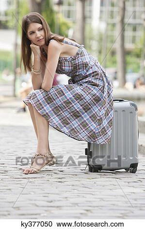 Woman sitting on the suitcase at the roadside, Paris, Ile-de-France, France View Large Photo Image Stock Image - Woman sitting on the suitcase at the roadside, Paris, Ile-de-France, France. Fotosearch