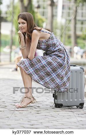 Woman sitting on the suitcase at the roadside, Paris, Ile-de-France, France View Large Photo Image Stock Photo - Woman sitting on the suitcase at the roadside, Paris, Ile-de-France, France. Fotosearch
