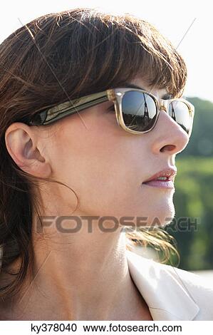 Stock Image - Close-up of a woman wearing sunglasses, Paris, Ile-de-France, France. Fotosearch