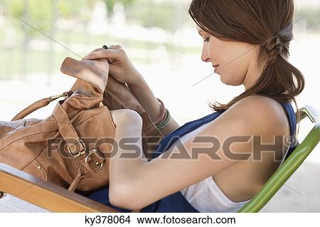 Picture - Woman checking her purse, Paris, Ile-de-France, France. Fotosearch