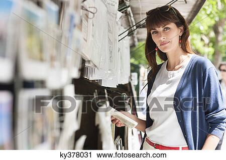 Woman holding a book at a book stall, Paris, Ile-de-France, France View Large Photo Image Stock Image - Woman holding a book at a book stall, Paris, Ile-de-France, France. Fotosearch