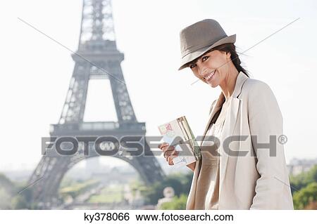 Stock Photograph - Woman holding a postcard with the Eiffel Tower in the background, Paris, Ile-de-France, France. Fotosearch