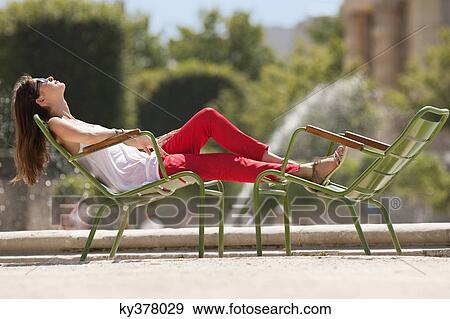 Stock Photo - Woman resting in a chair near a pond, Bassin octogonal, Jardin des Tuileries, Paris, Ile-de-France, France. Fotosearch