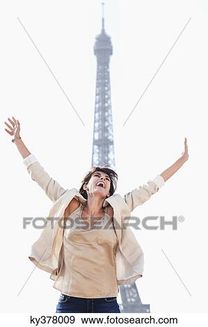 Stock Photo - Woman shouting in excitement with the Eiffel Tower in the background, Paris, Ile-de-France, France. Fotosearch