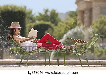Woman sitting in a chair and reading a magazine, Bassin octogonal, Jardin des Tuileries, Paris, Ile-de-France, France View Large Photo Image Stock Photograph - Woman sitting in a chair and reading a magazine, Bassin octogonal, Jardin des Tuileries, Paris, Ile-de-France, France. Fotosearch
