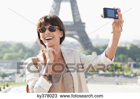 Woman taking a picture of herself with the Eiffel Tower in the background, Paris, Ile-de-France, France View Large Photo Image Stock Image - Woman taking a picture of herself with the Eiffel Tower in the background, Paris, Ile-de-France, France. Fotosearch