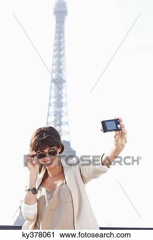 Woman taking a picture of herself with the Eiffel Tower in the background, Paris, Ile-de-France, France View Large Photo Image Stock Image - Woman taking a picture of herself with the Eiffel Tower in the background, Paris, Ile-de-France, France. Fotosearch