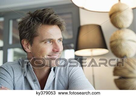 Close-up of a man smiling at home View Large Photo Image Stock Image - Close-up of a man smiling at home. Fotosearch