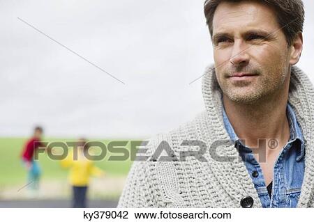 Close-up of a man thinking with his son and wife in the background View Large Photo Image Stock Image - Close-up of a man thinking with his son and wife in the background. Fotosearch