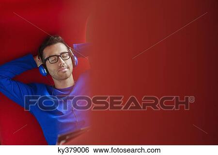 Man listening to headphones View Large Photo Image Stock Photograph - Man listening to headphones. Fotosearch