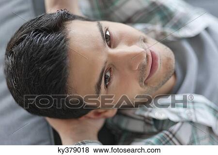Man lying on a couch and smiling View Large Photo Image Stock Photo - Man lying on a couch and smiling. Fotosearch