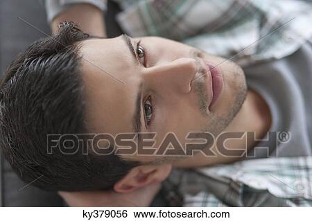 Man lying on a couch and thinking View Large Photo Image Stock Photograph - Man lying on a couch and thinking. Fotosearch