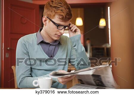 Stock Photograph - Man reading a newspaper in a restaurant. Fotosearch