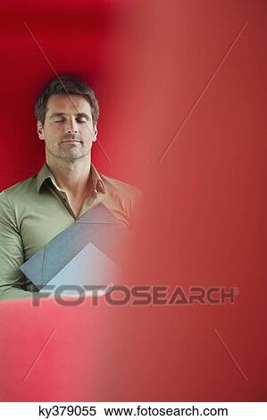 Man resting with eyes closed in an office View Large Photo Image Stock Photography - Man resting with eyes closed in an office. Fotosearch