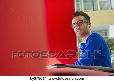 Picture - Man sitting in an office. Fotosearch