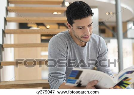 Man sitting on stairs and reading a magazine View Large Photo Image Stock Photo - Man sitting on stairs and reading a magazine. Fotosearch