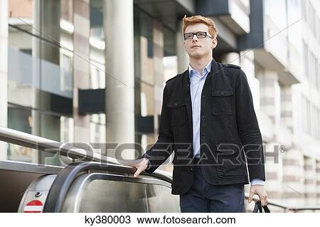 Businessman standing on escalator View Large Photo Image Stock Image - Businessman standing on escalator. Fotosearch