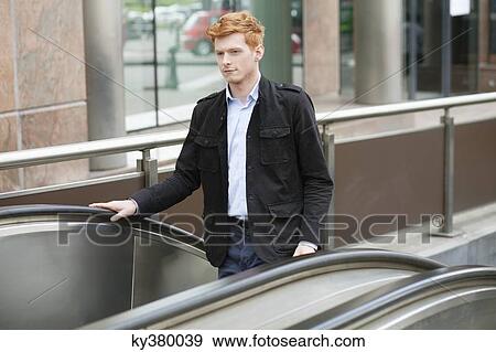 Businessman standing on escalator moving up View Large Photo Image Stock Photo - Businessman standing on escalator moving up. Fotosearch