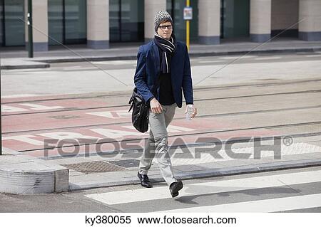 Businessman walking at the roadside View Large Photo Image Stock Photography - Businessman walking at the roadside. Fotosearch