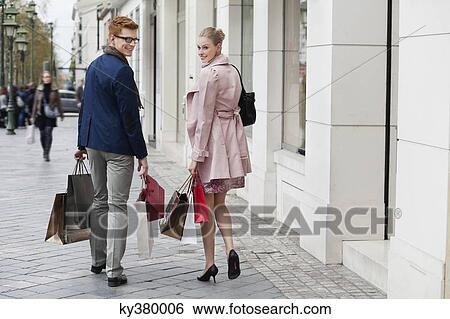 Couple carrying shopping bags View Large Photo Image Stock Photograph - Couple carrying shopping bags. Fotosearch