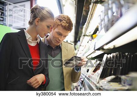 Couple shopping in a supermarket View Large Photo Image Picture - Couple shopping in a supermarket. Fotosearch